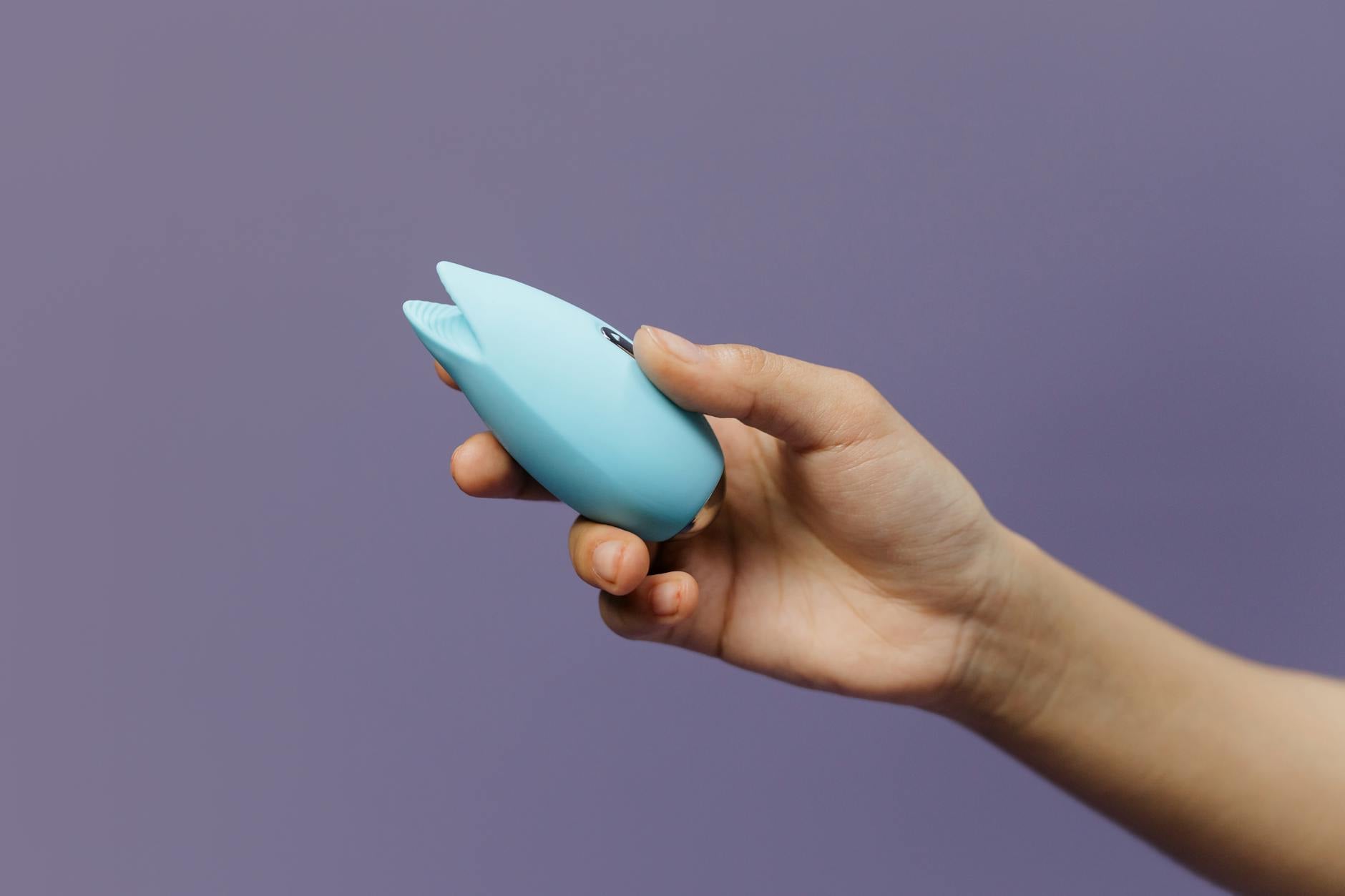 A blue silicone lemon vibrator held in hand, representing pleasure recovery and sensation restoration