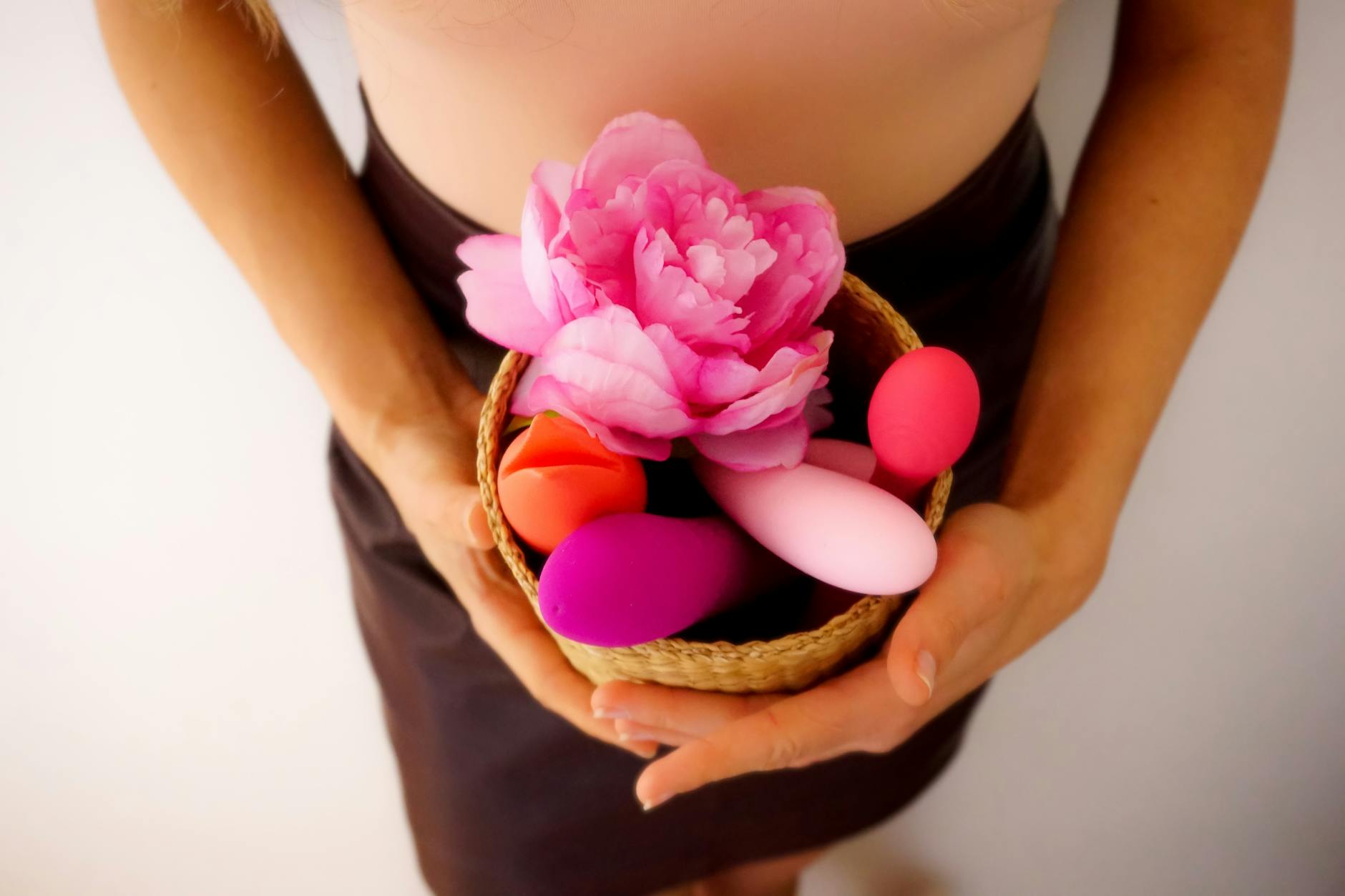 Woman thoughtfully holding a personal vibrator, exploring pleasure and sensation